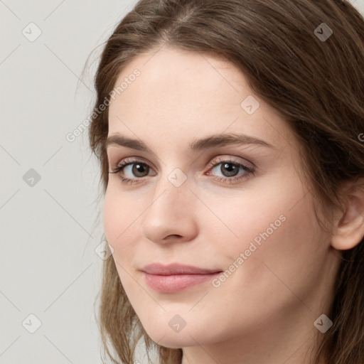 Joyful white young-adult female with long  brown hair and green eyes