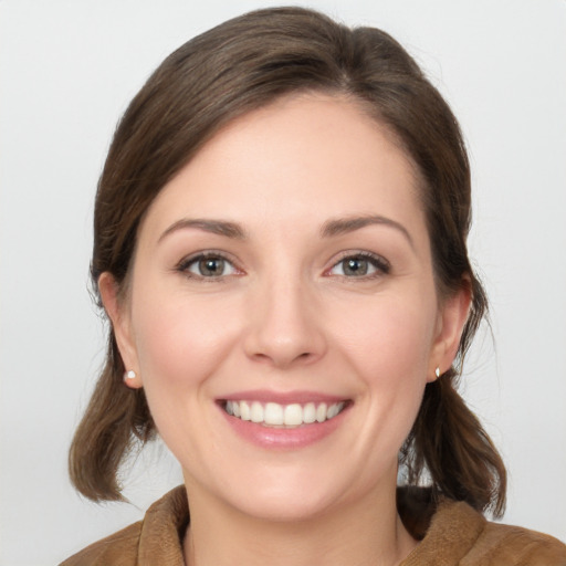 Joyful white young-adult female with medium  brown hair and grey eyes