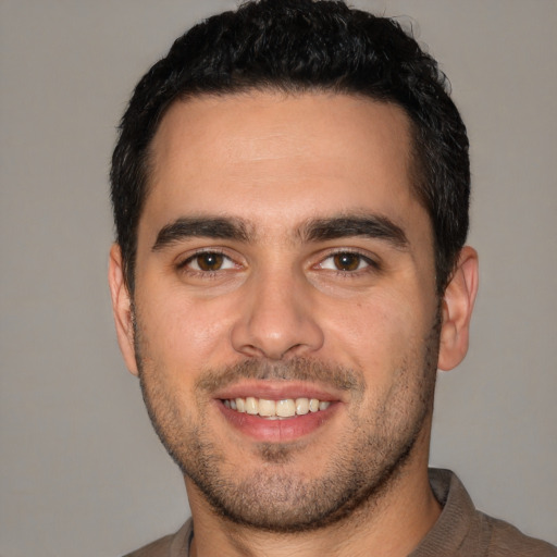 Joyful white young-adult male with short  black hair and brown eyes