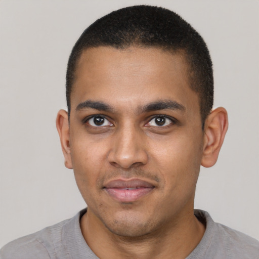 Joyful black young-adult male with short  black hair and brown eyes