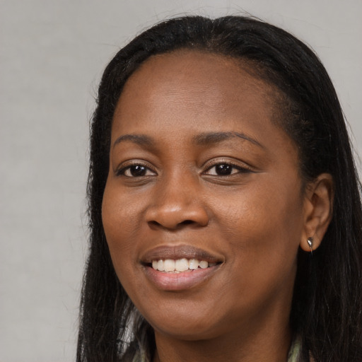 Joyful black young-adult female with long  black hair and brown eyes