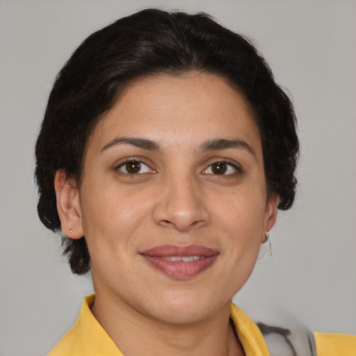 Joyful latino adult female with medium  brown hair and brown eyes