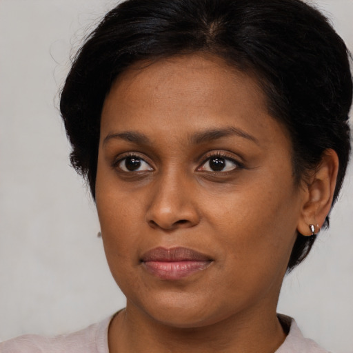 Joyful black adult female with medium  brown hair and brown eyes