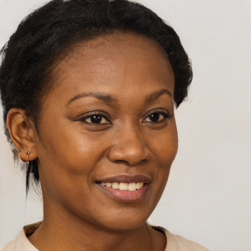 Joyful black young-adult female with short  brown hair and brown eyes