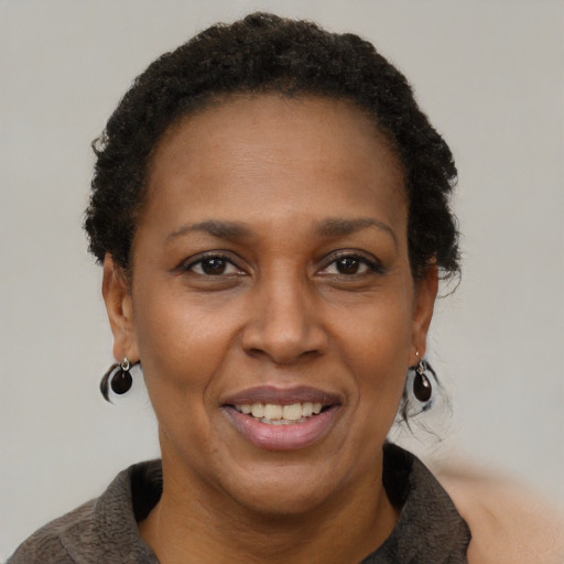 Joyful black adult female with short  brown hair and brown eyes