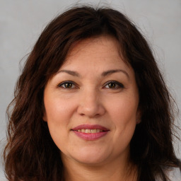 Joyful white adult female with long  brown hair and brown eyes