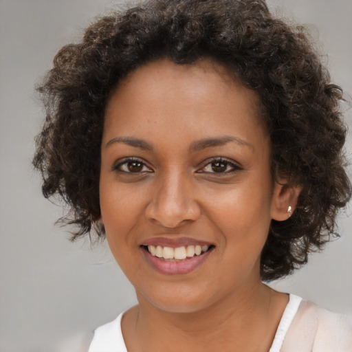 Joyful black young-adult female with medium  brown hair and brown eyes