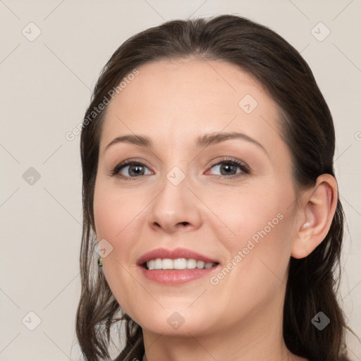 Joyful white young-adult female with long  brown hair and brown eyes