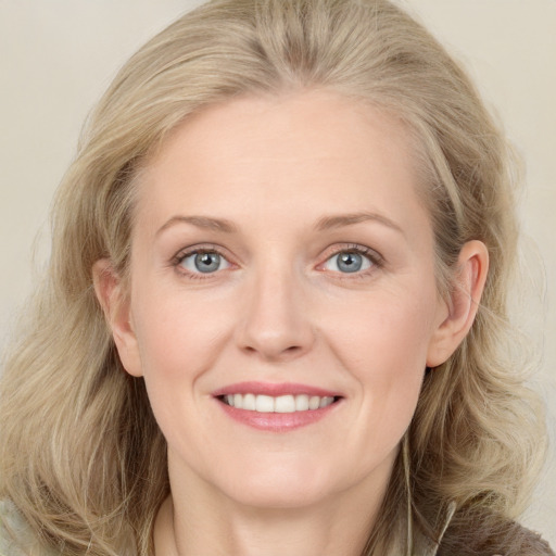 Joyful white young-adult female with long  brown hair and blue eyes