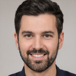 Joyful white young-adult male with short  black hair and brown eyes