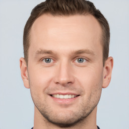 Joyful white young-adult male with short  brown hair and grey eyes