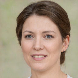 Joyful white young-adult female with medium  brown hair and green eyes