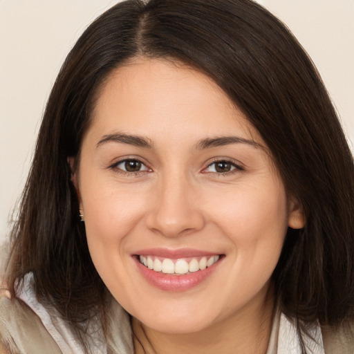 Joyful white young-adult female with long  brown hair and brown eyes