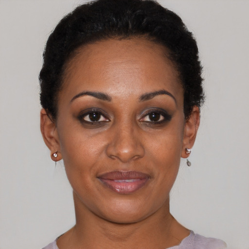 Joyful black young-adult female with short  black hair and brown eyes