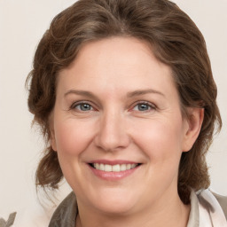 Joyful white adult female with medium  brown hair and grey eyes