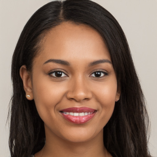 Joyful black young-adult female with long  brown hair and brown eyes