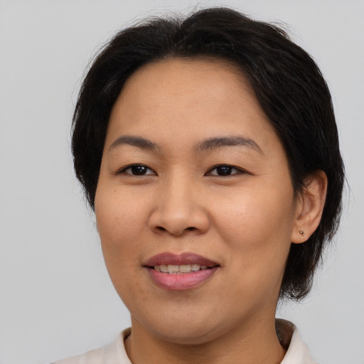 Joyful asian adult female with medium  brown hair and brown eyes
