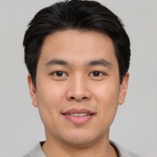 Joyful asian young-adult male with short  brown hair and brown eyes