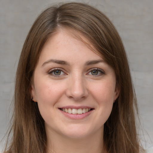 Joyful white young-adult female with long  brown hair and grey eyes