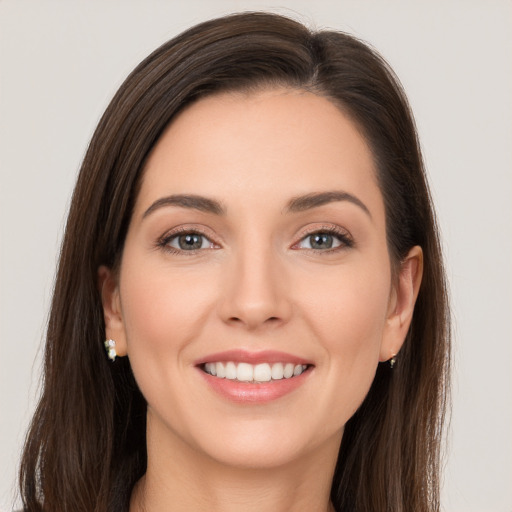 Joyful white young-adult female with long  brown hair and brown eyes