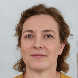 Joyful white adult female with medium  brown hair and blue eyes