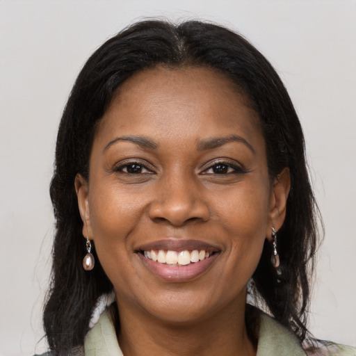 Joyful black adult female with long  brown hair and brown eyes