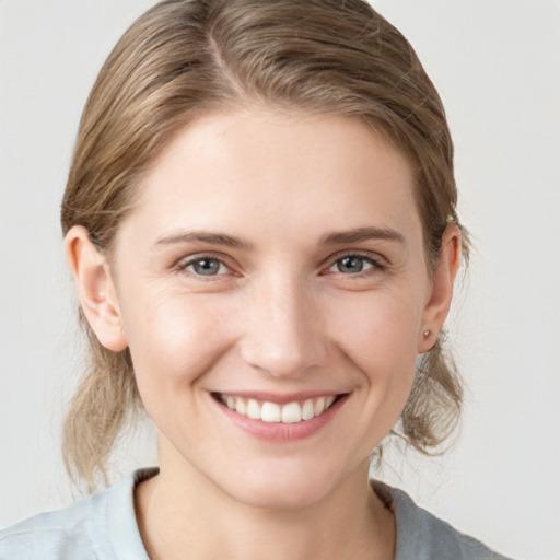 Joyful white young-adult female with medium  brown hair and grey eyes