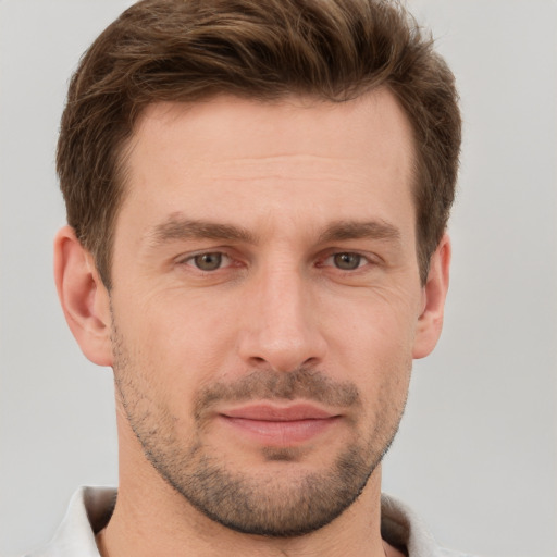 Joyful white young-adult male with short  brown hair and grey eyes