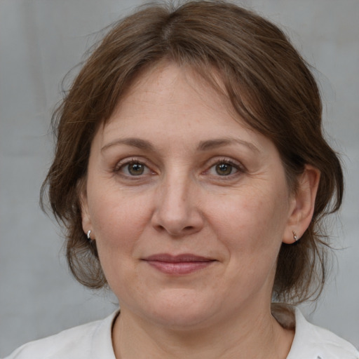 Joyful white adult female with medium  brown hair and grey eyes