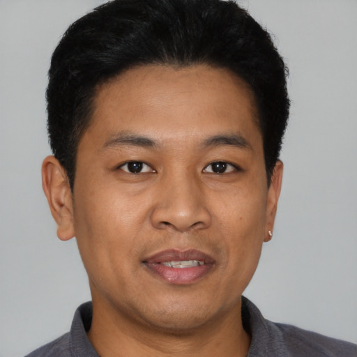 Joyful asian young-adult male with short  black hair and brown eyes