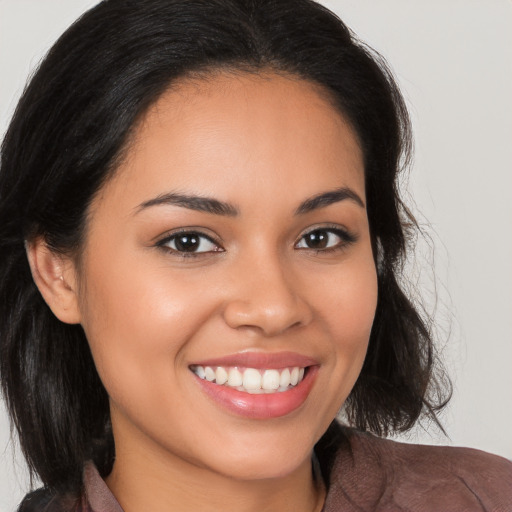 Joyful latino young-adult female with long  brown hair and brown eyes