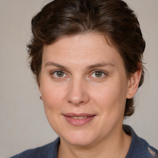 Joyful white adult female with medium  brown hair and blue eyes