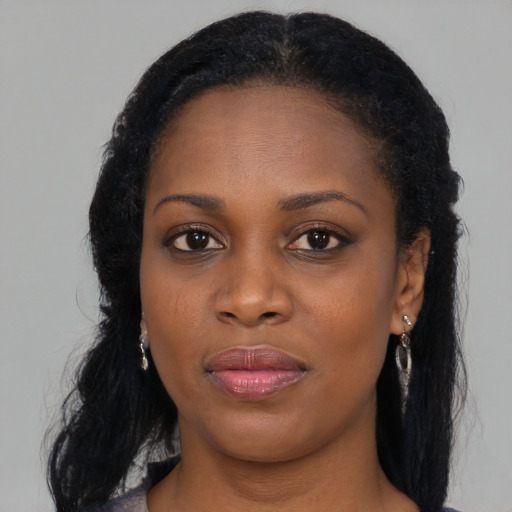 Joyful black young-adult female with long  black hair and brown eyes