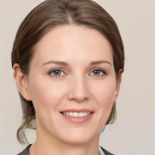 Joyful white young-adult female with medium  brown hair and grey eyes