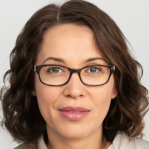 Joyful white adult female with medium  brown hair and green eyes