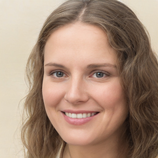 Joyful white young-adult female with long  brown hair and green eyes