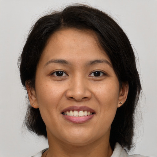 Joyful latino young-adult female with medium  brown hair and brown eyes