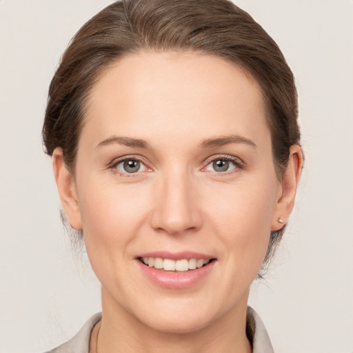 Joyful white young-adult female with medium  brown hair and grey eyes