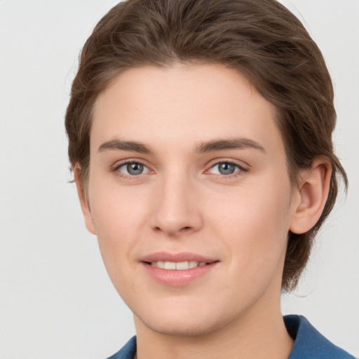 Joyful white young-adult female with short  brown hair and grey eyes