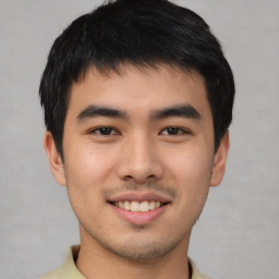 Joyful asian young-adult male with short  brown hair and brown eyes