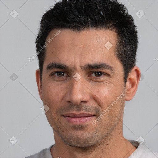 Joyful white adult male with short  black hair and brown eyes