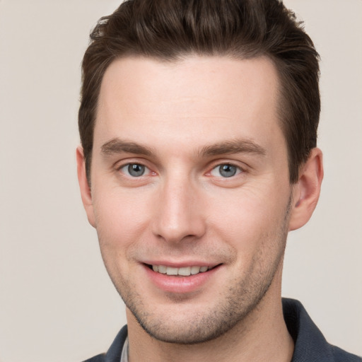 Joyful white young-adult male with short  brown hair and grey eyes