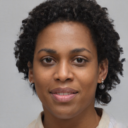 Joyful black young-adult female with medium  black hair and brown eyes