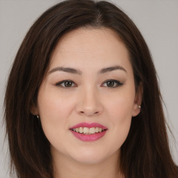 Joyful asian young-adult female with long  brown hair and brown eyes