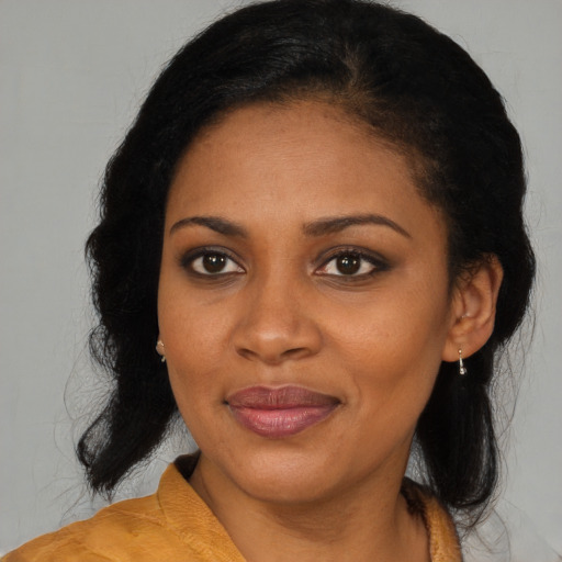 Joyful black young-adult female with long  brown hair and brown eyes