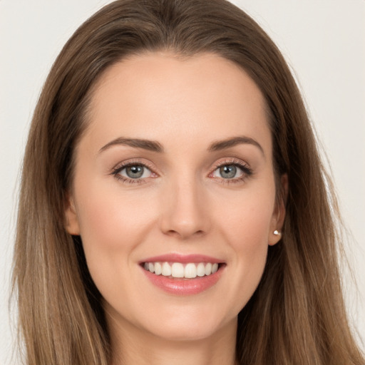 Joyful white young-adult female with long  brown hair and brown eyes