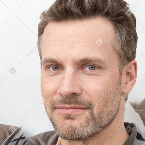 Joyful white adult male with short  brown hair and grey eyes