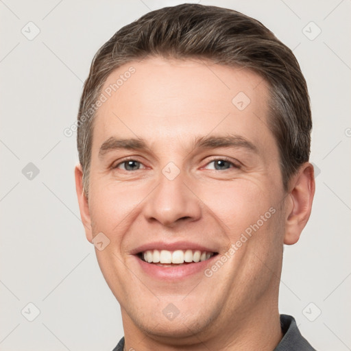 Joyful white adult male with short  brown hair and grey eyes