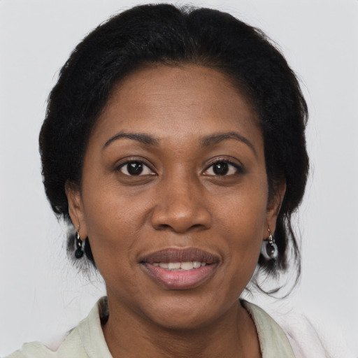 Joyful black adult female with medium  brown hair and brown eyes