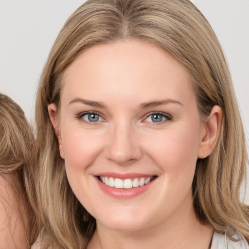 Joyful white young-adult female with long  brown hair and grey eyes